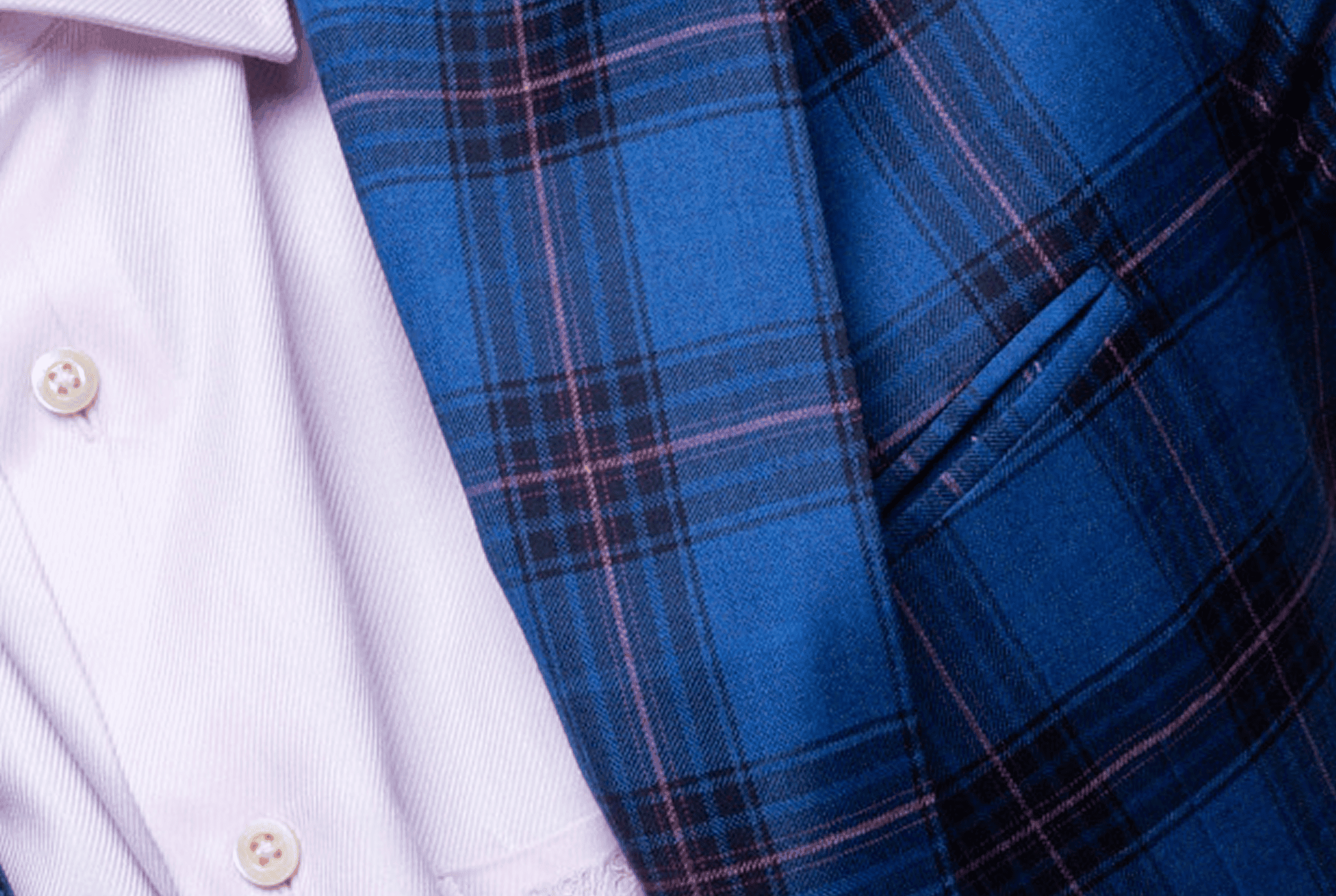 Close-up of a blue plaid suit jacket over a white dress shirt.