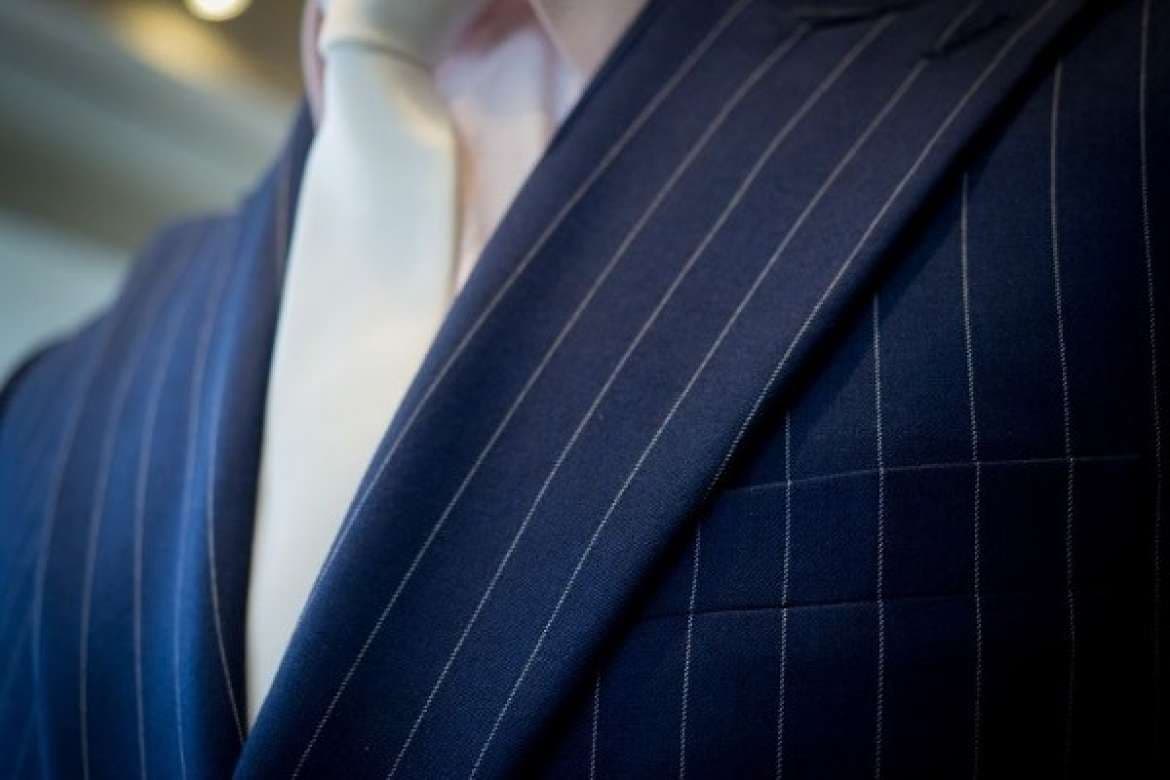 Dress shirt and suit combination styled with a tie.