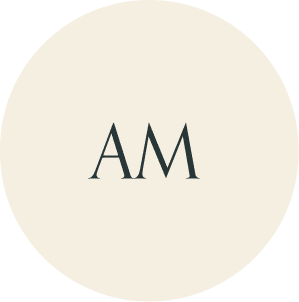 Cream circular monogram with AM initials.
