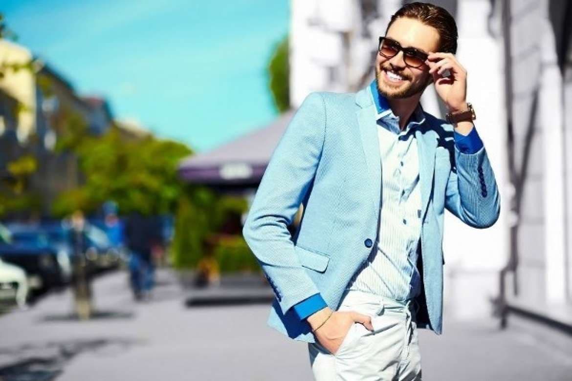 Man in a light blue summer blazer wearing sunglasses outdoors.