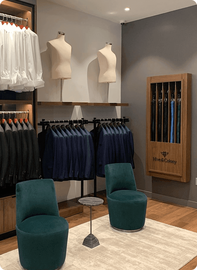 Showroom lounge with green chairs, jacket racks, and an umbrella display.