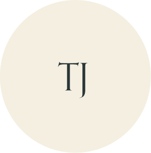Cream circular monogram with TJ initials.
