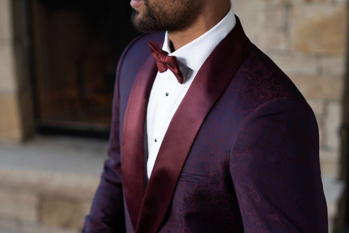 Man wearing a black tuxedo jacket with formal eveningwear details.