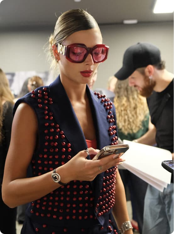 Fashion students selecting garments and fabrics from clothing racks during the Marangoni collaboration.