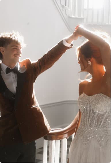 Bride twirling while holding hands with groom on a staircase.