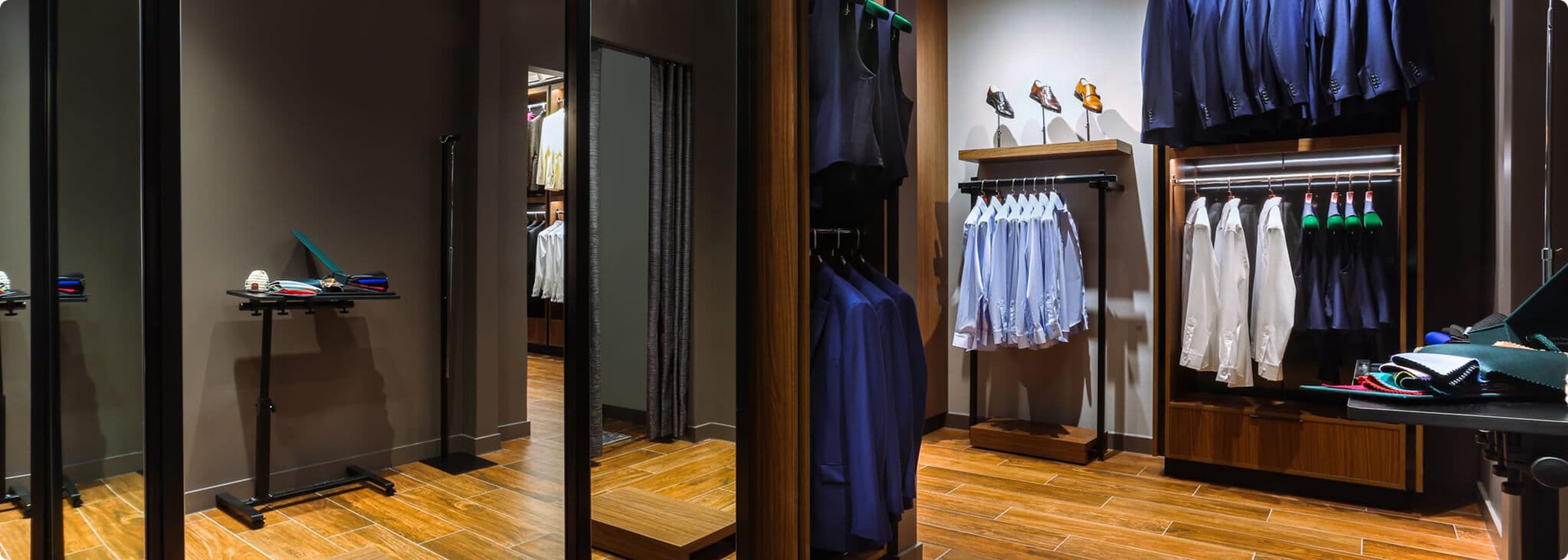 Showroom fitting rooms with shirts, jackets, and tailoring displays.