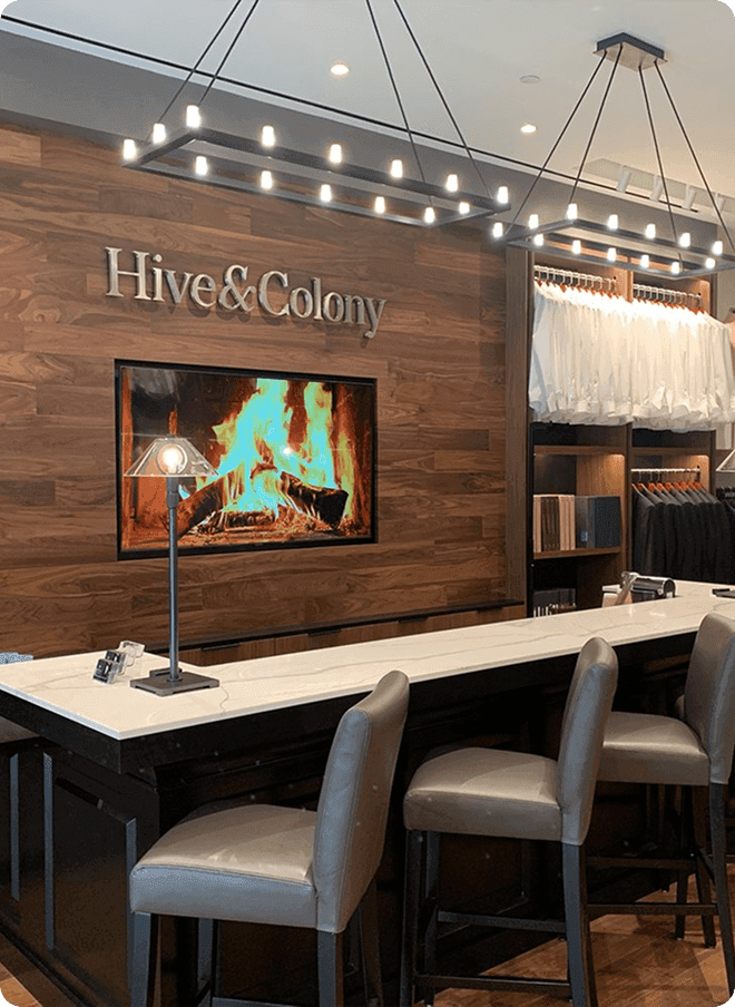 Fitting bar with fireplace screen, white shirts, and showroom seating.