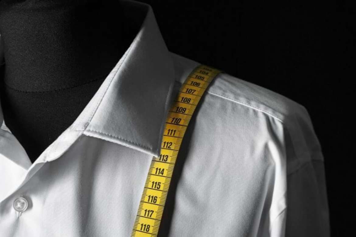 Bespoke dress shirts arranged in a menswear display.