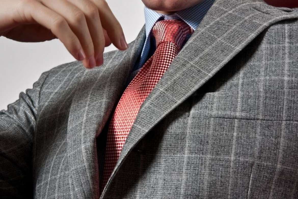 Man trying on a tailored suit jacket.