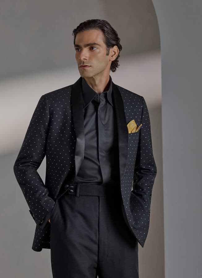 Man in a black studded tuxedo jacket with satin lapels.