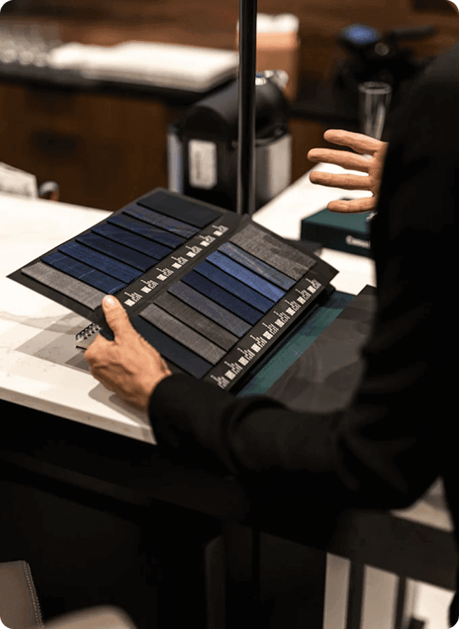 Person presenting blue and gray fabric swatches at a fitting counter.