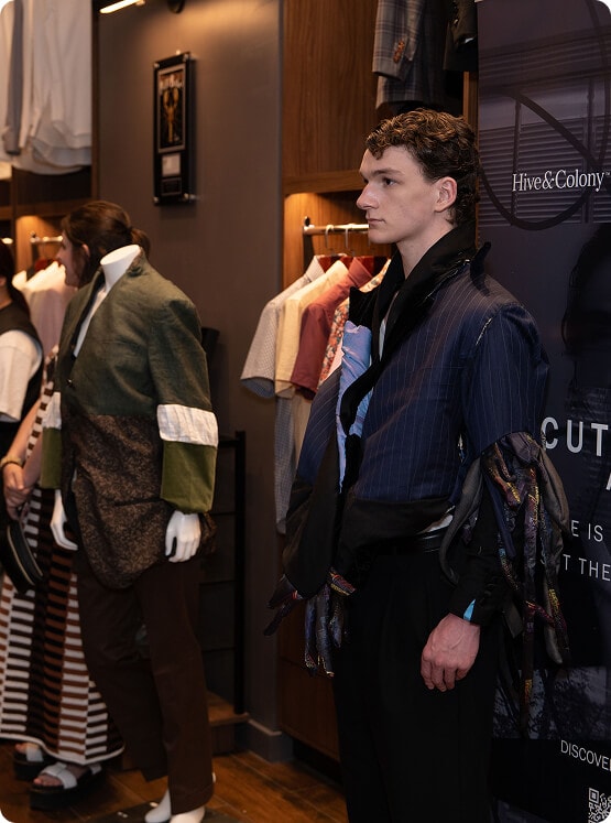 Male model wearing a deconstructed navy jacket at the A Cut Above showcase.