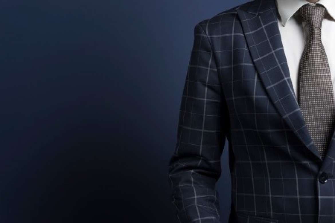 Man wearing a navy windowpane suit with a patterned tie.