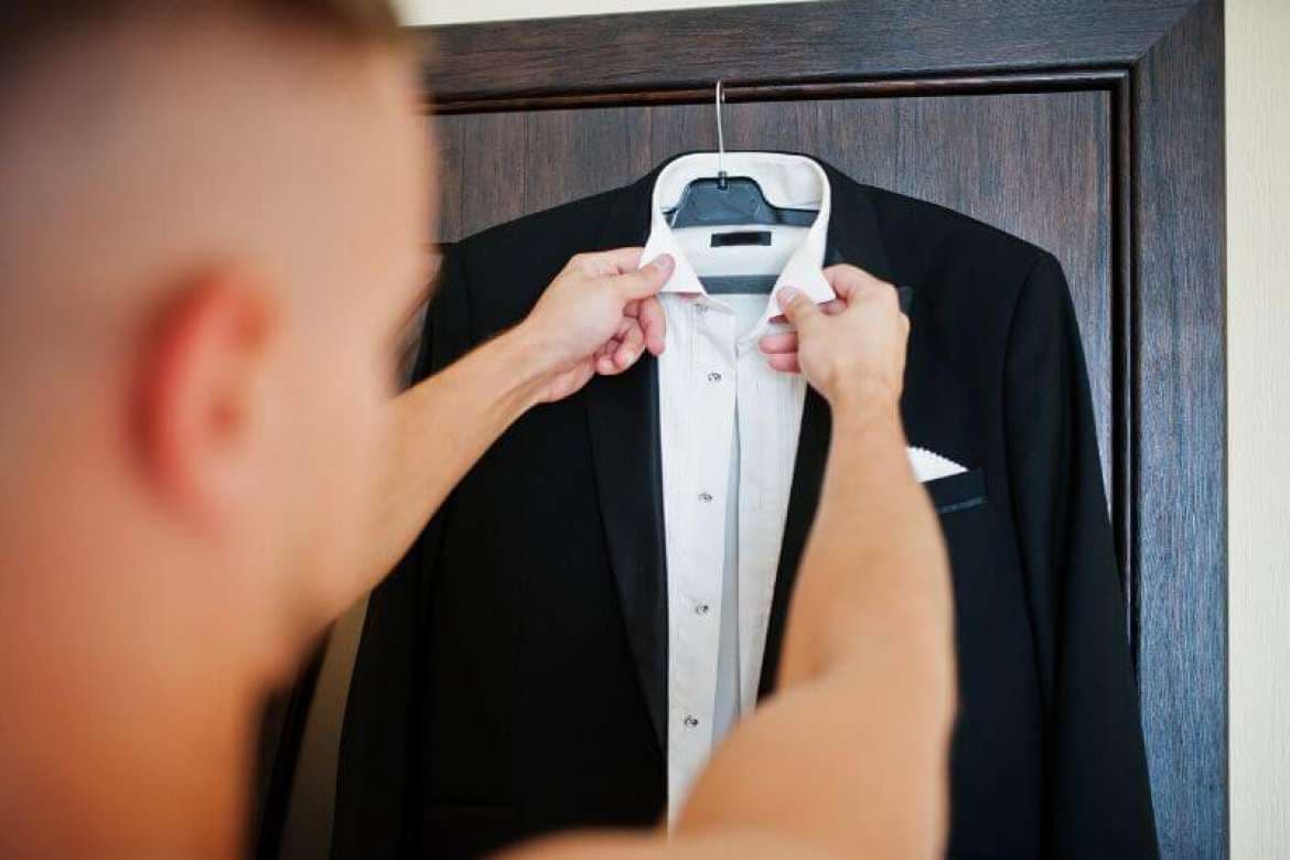 Black tuxedo jacket hanging with a white dress shirt.