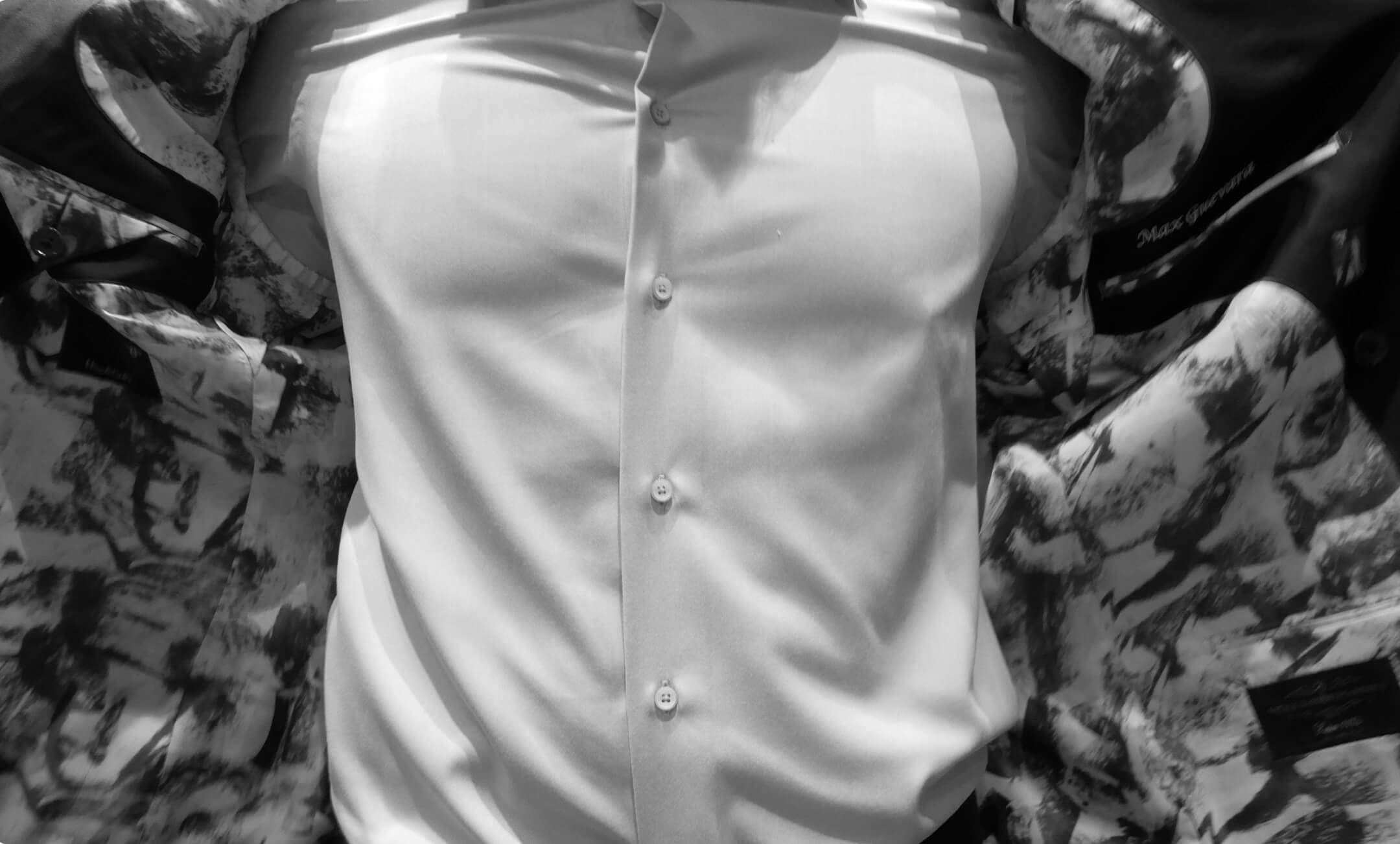 Black-and-white close-up of a suit jacket opening to reveal patterned lining.