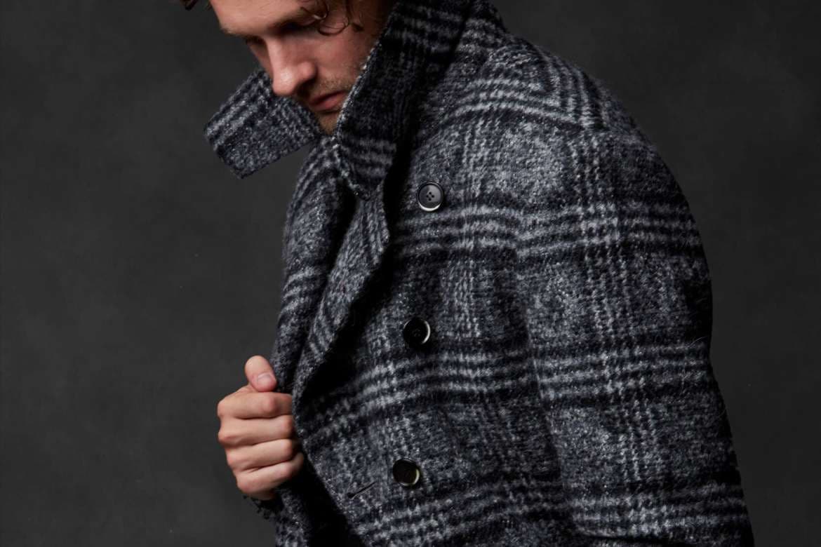 Bespoke overcoat displayed with tailored menswear.