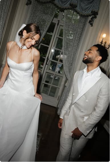 Bride and groom smiling together in an elegant room.