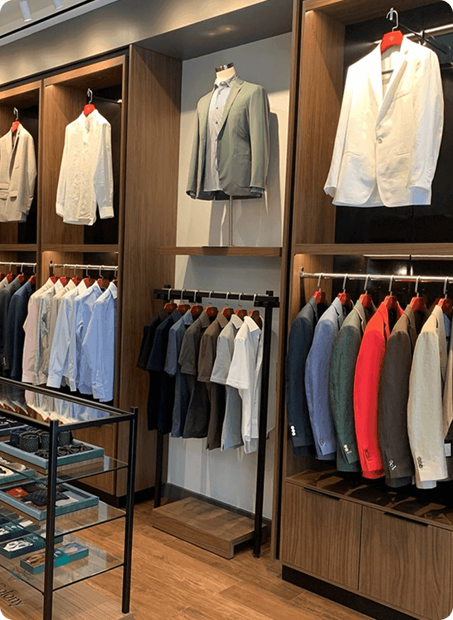 Wooden menswear displays with shirts, jackets, and accessories.