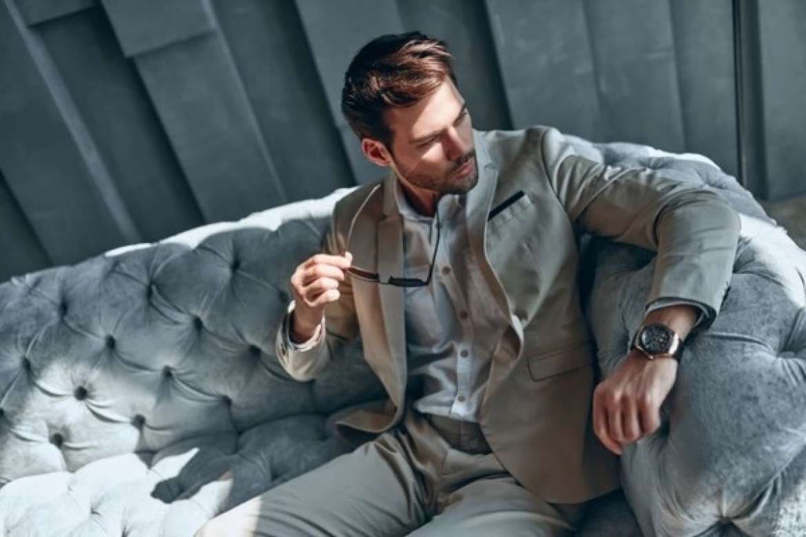 Man in a sharp tailored suit posing confidently.